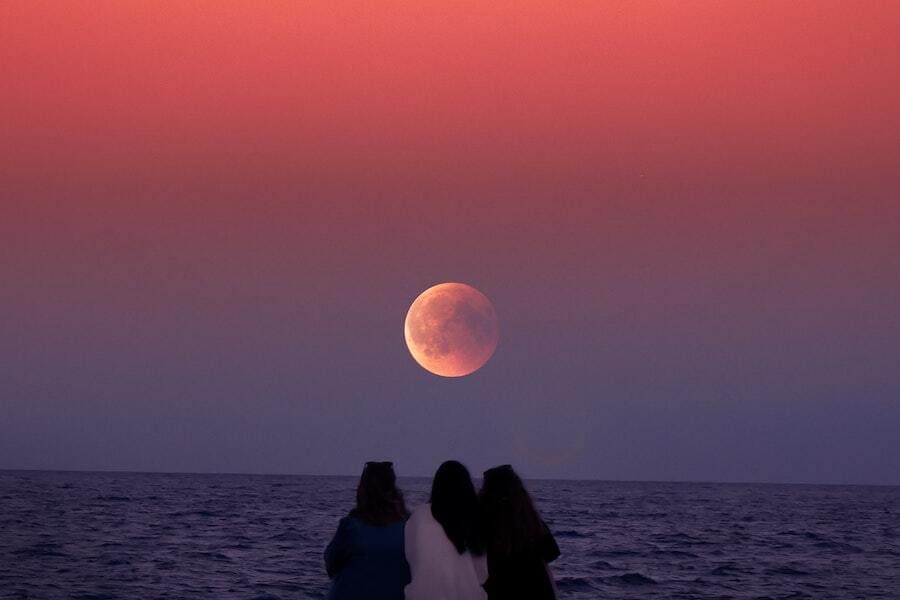 two people looking at the strawberry moon