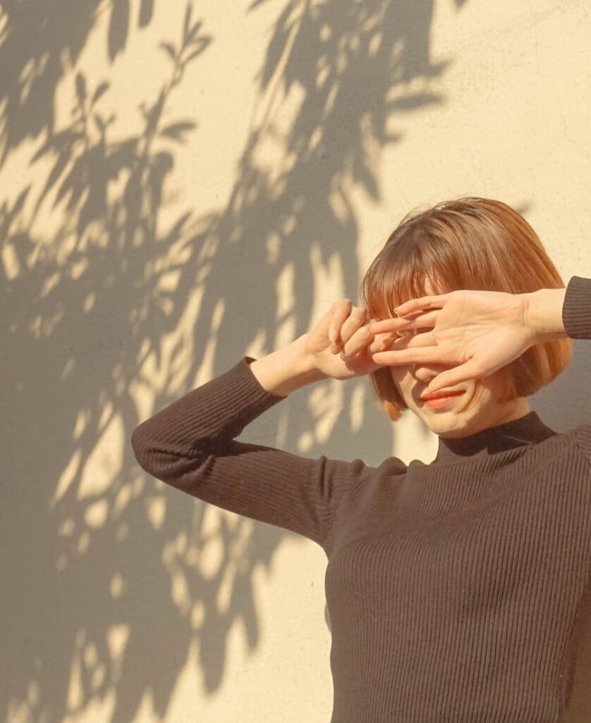 woman covering her eyes from the sun