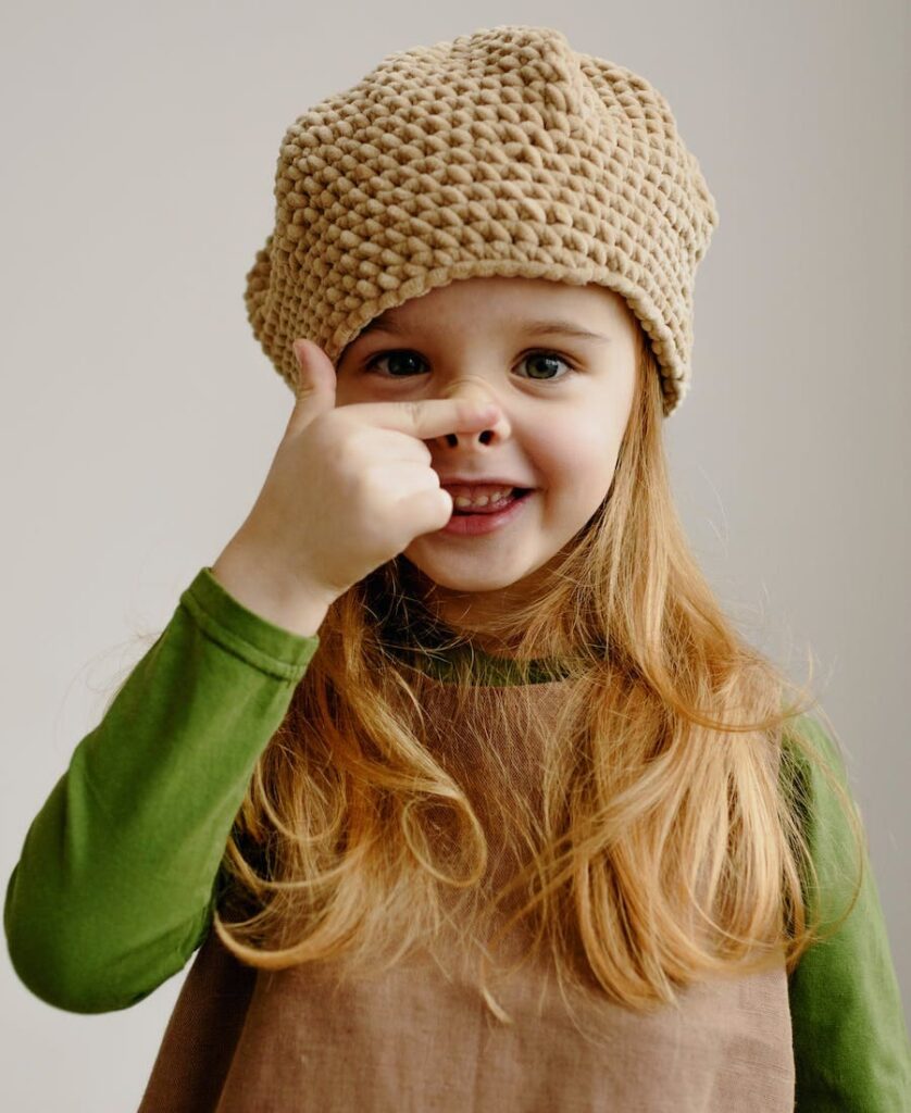 Child touching her nose